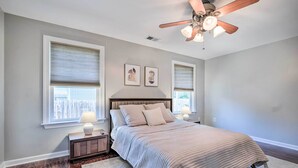 A bedroom with a bed, nightstands, a ceiling fan, and two windows with blinds. - Idyllic Pasadena Retreat With Garden + Hot Tub! (Pasadena)