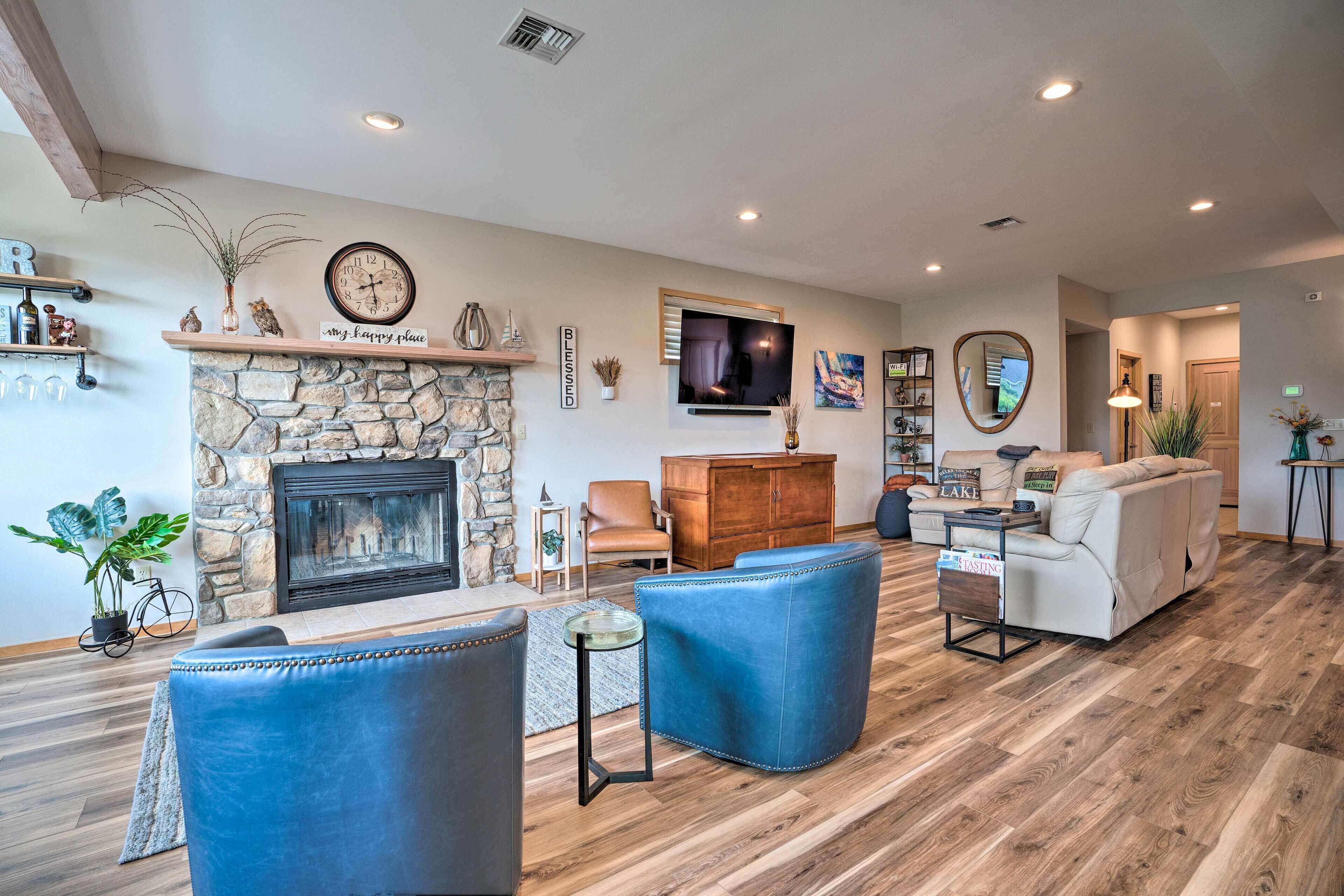 A spacious living room with a stone fireplace, leather sofas, a flat-screen TV, and a cozy seating area.