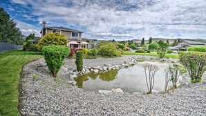 A residential area with a pond, well-maintained lawn, and houses with distinct architectural styles. - Lake Chelan Home in Private Community w/ Lake View (Manson)
