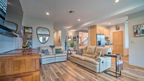 A spacious living room with a wooden coffee table, two sofas, and a kitchen in the background. - Lake Chelan Home in Private Community w/ Lake View (Manson)