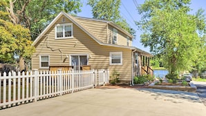 A two-story house with a white picket fence, a front porch, and a driveway. - Sunny Glen Burnie Home - On-site Water Access (Glen Burnie)