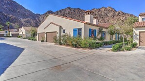 A residential area with houses featuring red-tiled roofs, a paved driveway, and a mountain backdrop. - 243460: 3BR Desert Retreat w/ Views + Pool Access (La Quinta)