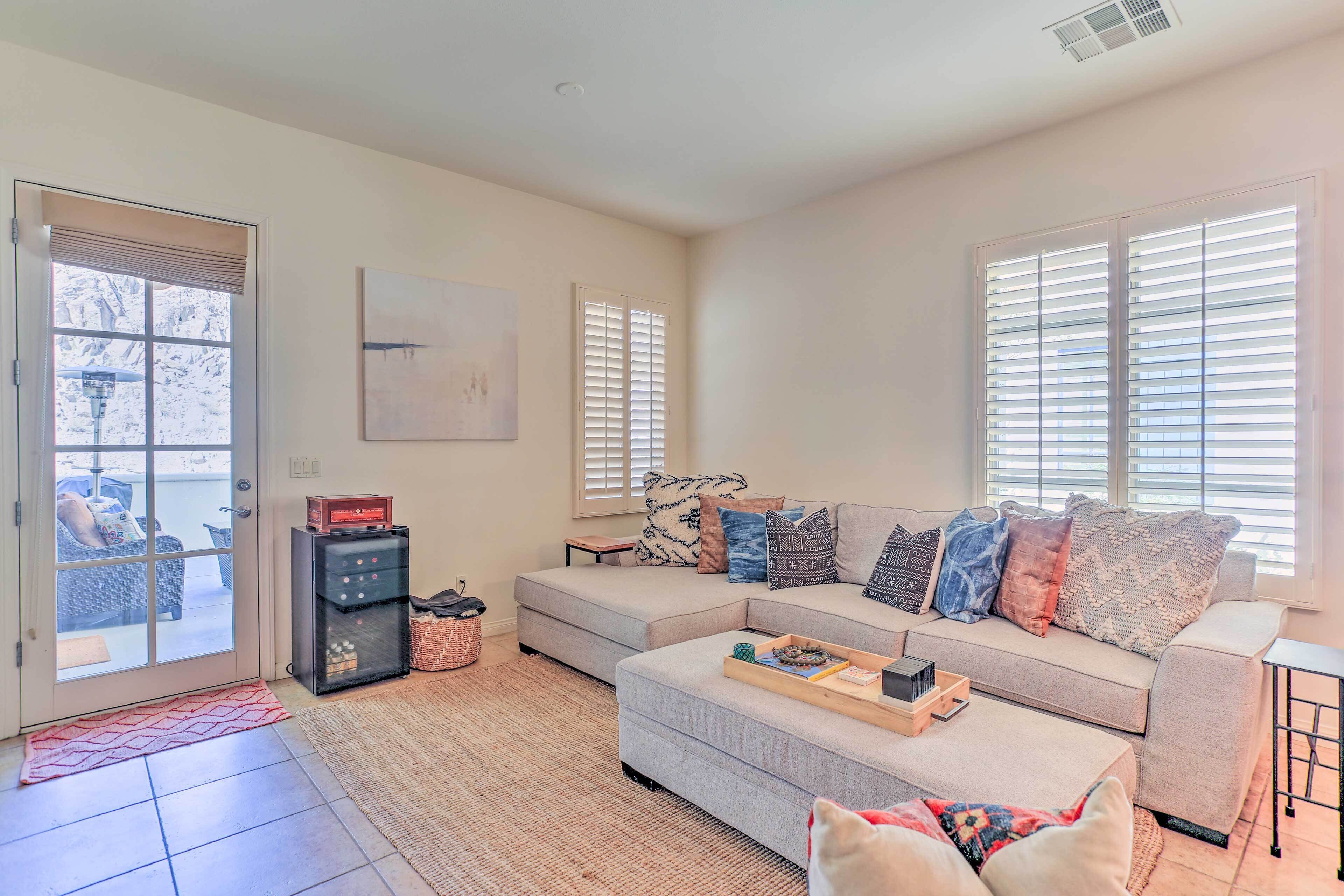 A living room with a sectional sofa, a coffee table, and a fireplace.
