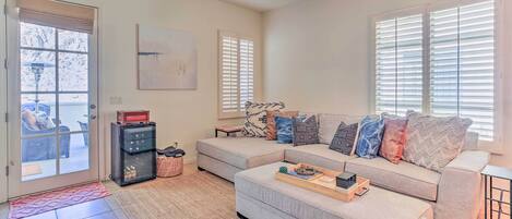 A living room with a sectional sofa, a coffee table, and a fireplace.