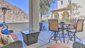 A patio area with wicker furniture, a table, and a grill. - 243460: 3BR Desert Retreat w/ Views + Pool Access (La Quinta)
