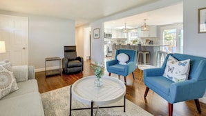 A living room with a sofa, two armchairs, a coffee table, and a view into the kitchen. - Families Welcome! Home 2 Mi to Craigville Beach (Hyannis)