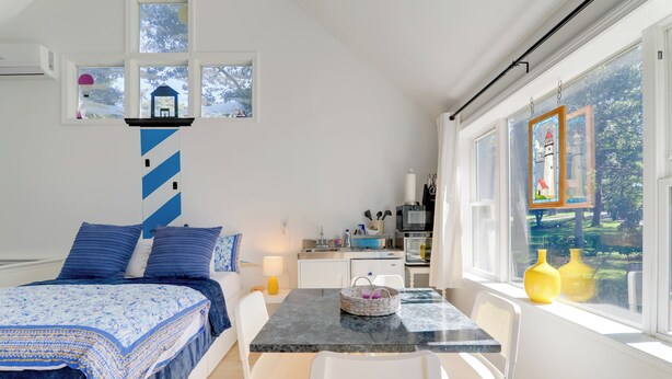 Een moderne, goed verlichte kamer met een bed, een eettafel en uitzicht op het omliggende landschap.