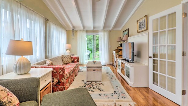Una sala de estar acogedora con un sofá, un televisor y una alfombra decorativa.