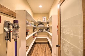 A pantry with shelves stocked with food items, a coffee maker, and a pot on the top shelf. - Bigfork Modern Living - Pet & Family Friendly! (Bigfork)