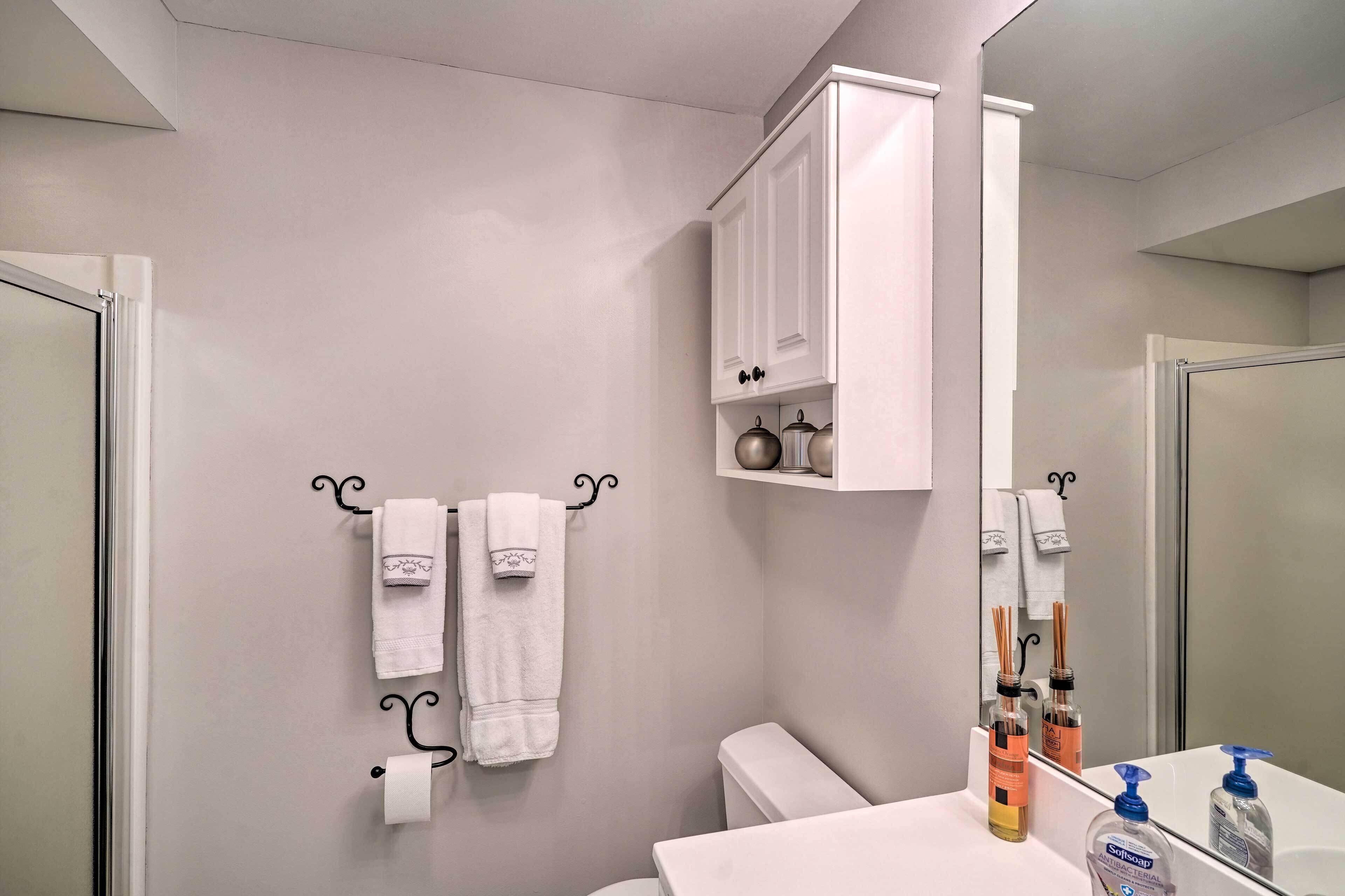 A bathroom with a toilet, a sink, a mirror, and a cabinet above the sink.