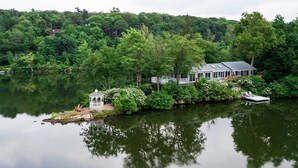 A lakeside house with a dock, surrounded by dense forest.