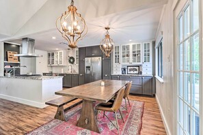 A spacious kitchen with a central island, dark cabinets, and a large window. - Pet-friendly Austin Ranch Home w/ Fire Pit! (Austin)
