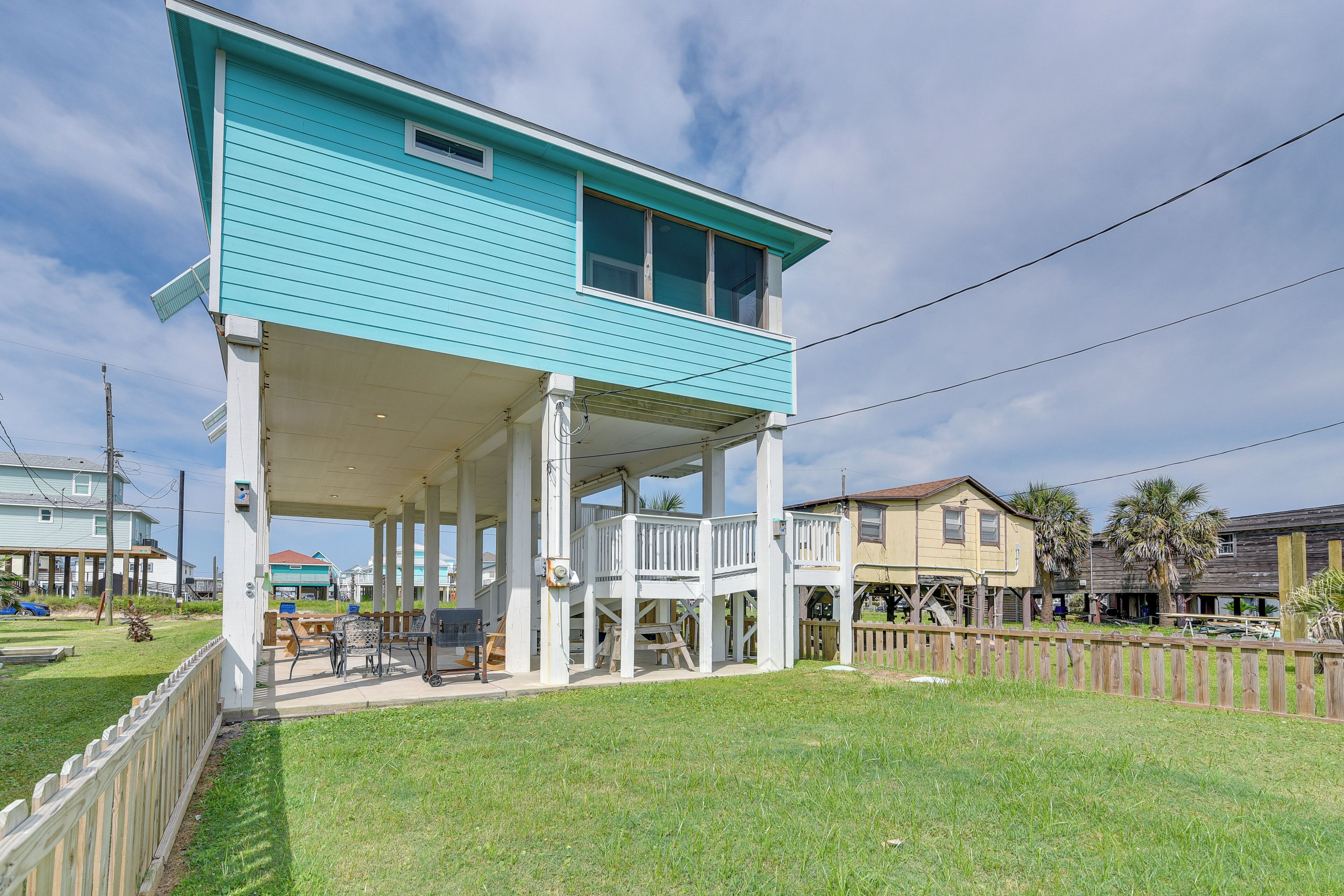 A two-story house with a covered porch and a fenced yard.
