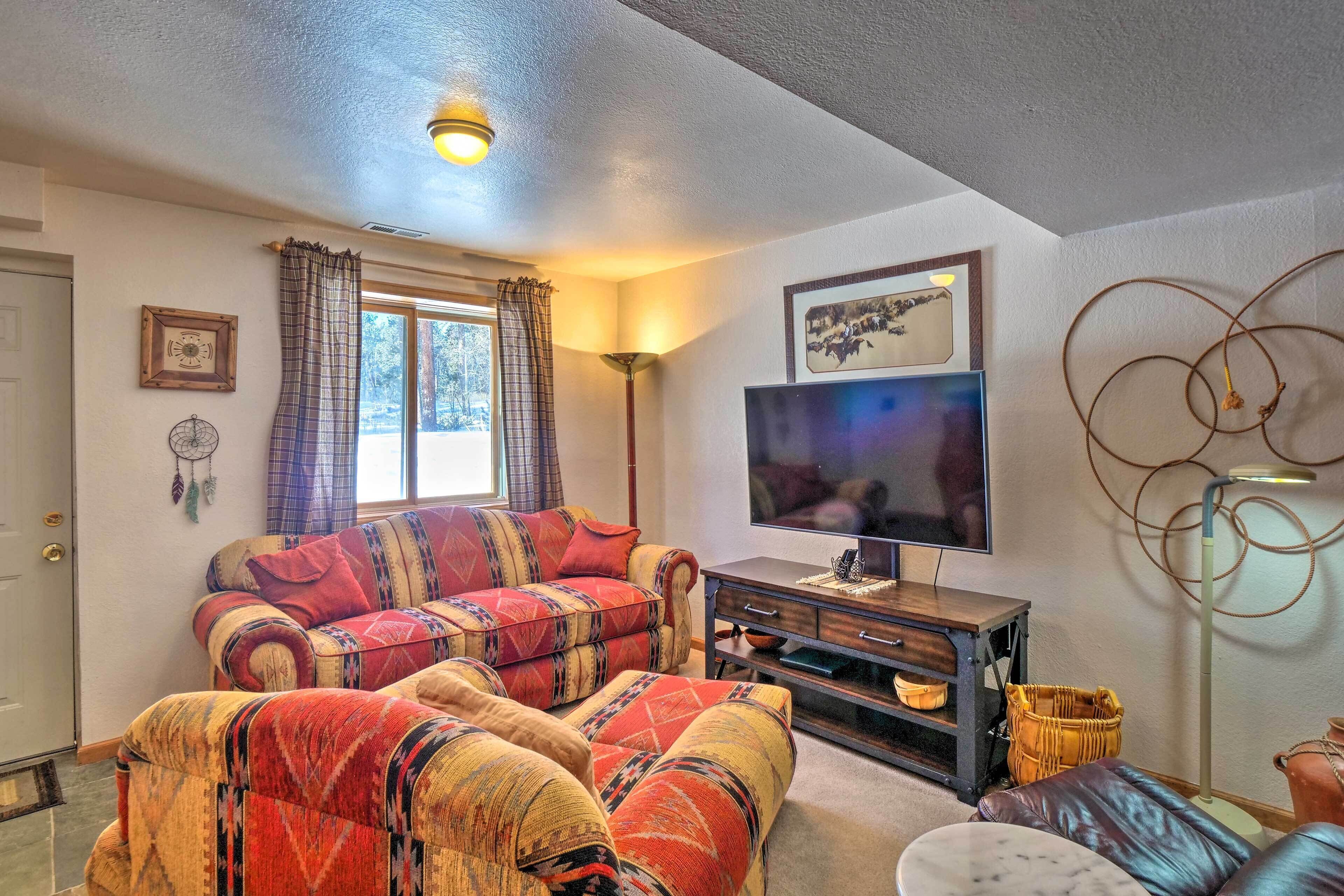 A living room with a sofa set, a television, and a lamp.