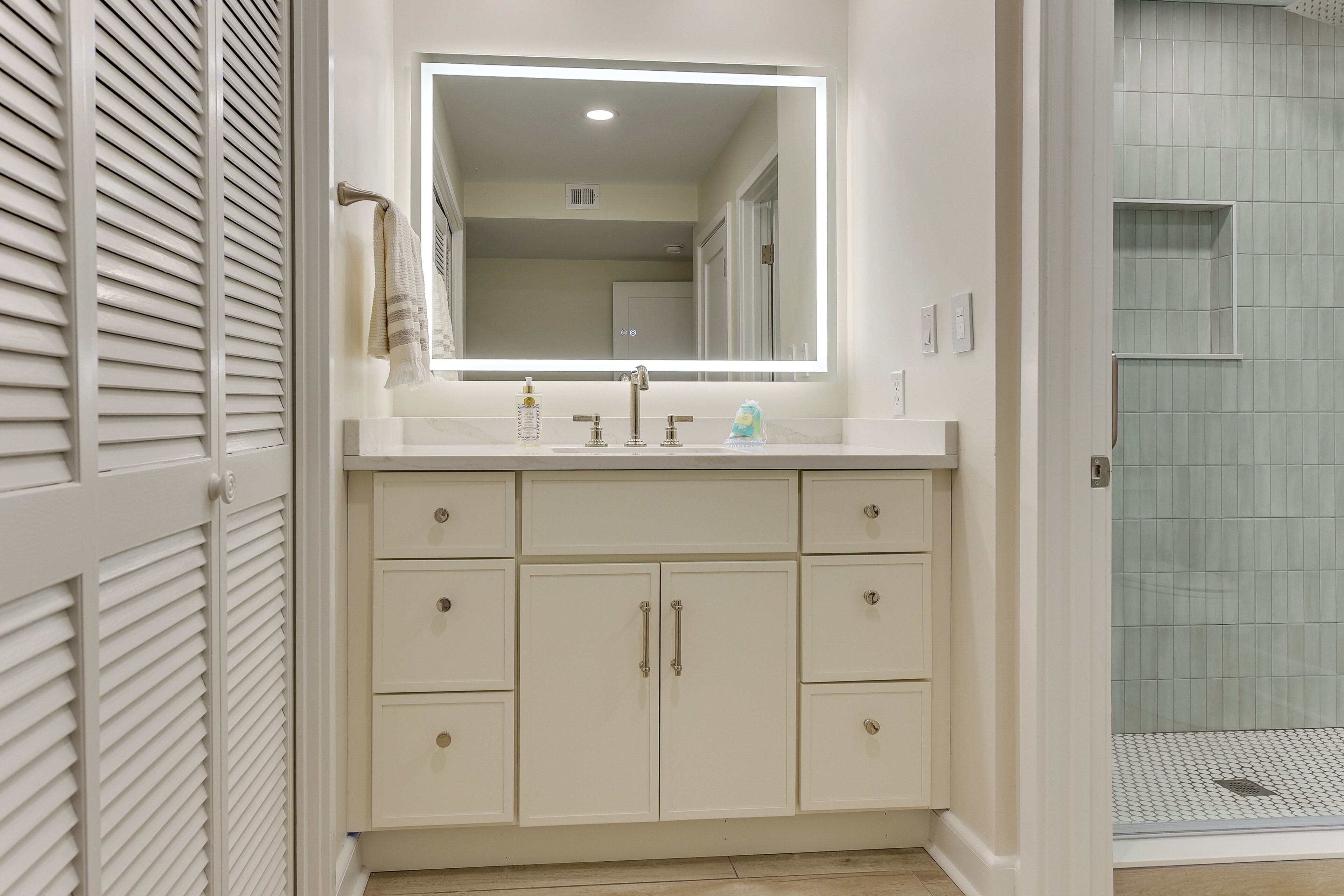 Une salle de bain avec un meuble-lavabo, un miroir et une douche.