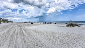 A beach with a sandy path leading to the water, umbrellas, and people. - Palmetto Dunes Villa w/ Views: Steps to Beach! (Hilton Head Island)