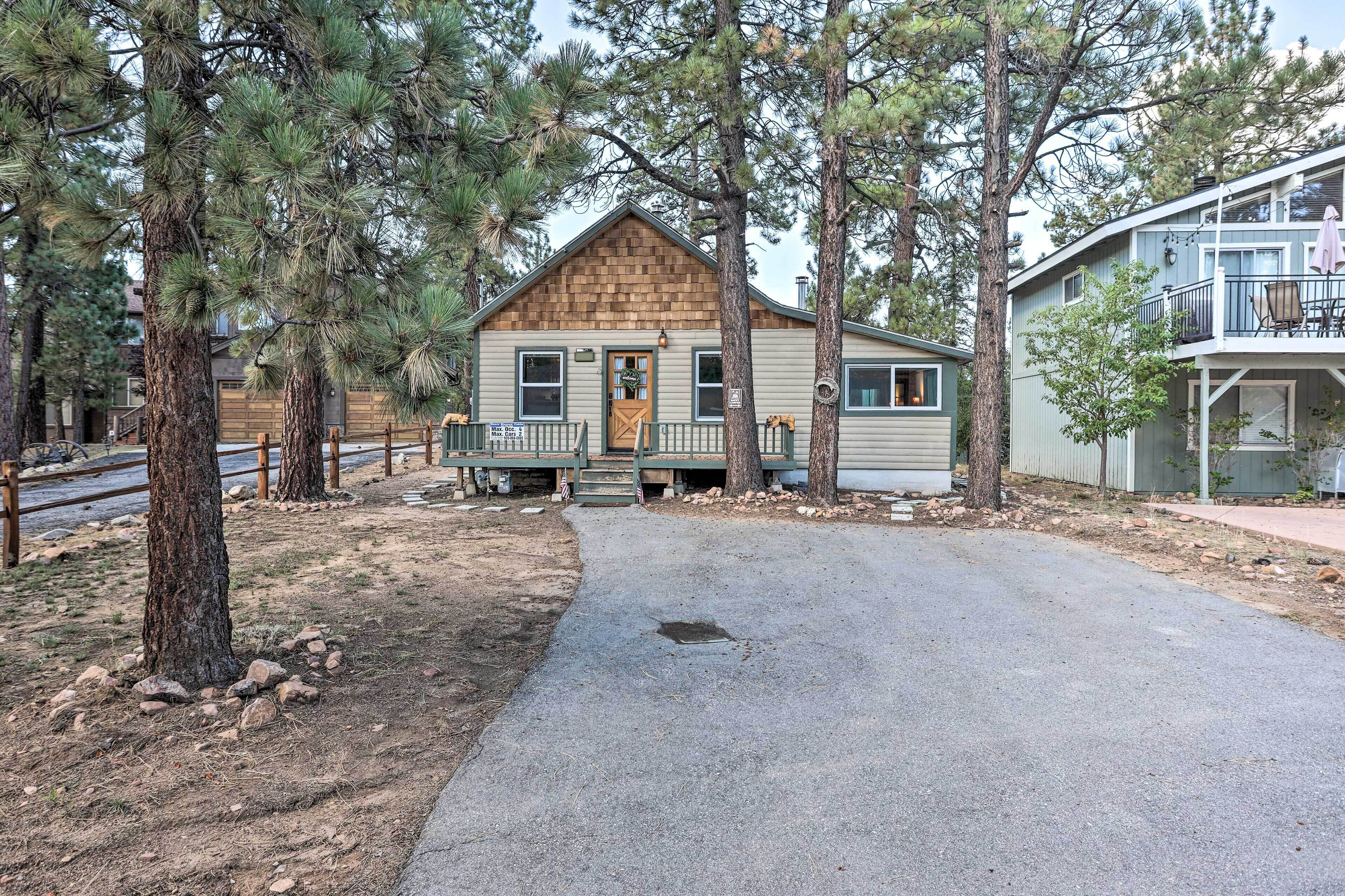 A cabin with a wooden front, a porch, and a small deck.