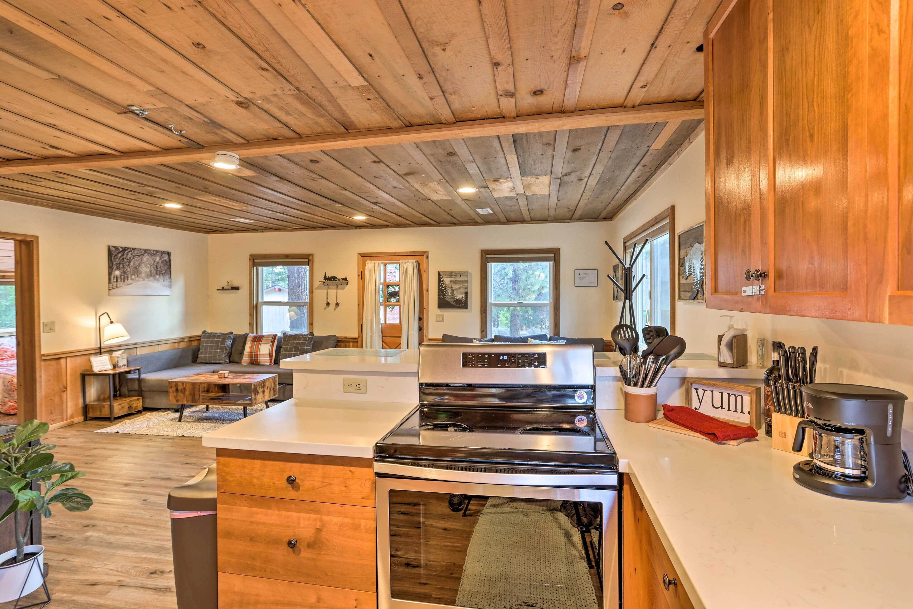 Una cocina amplia con armarios de madera, una cocina grande y una cafetera.