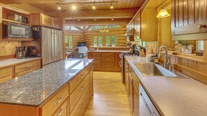 A spacious kitchen with granite countertops, wooden cabinets, and stainless steel appliances. - Waterfront Escape on Caribou Lake: Dock + Fire Pit (Lutsen)