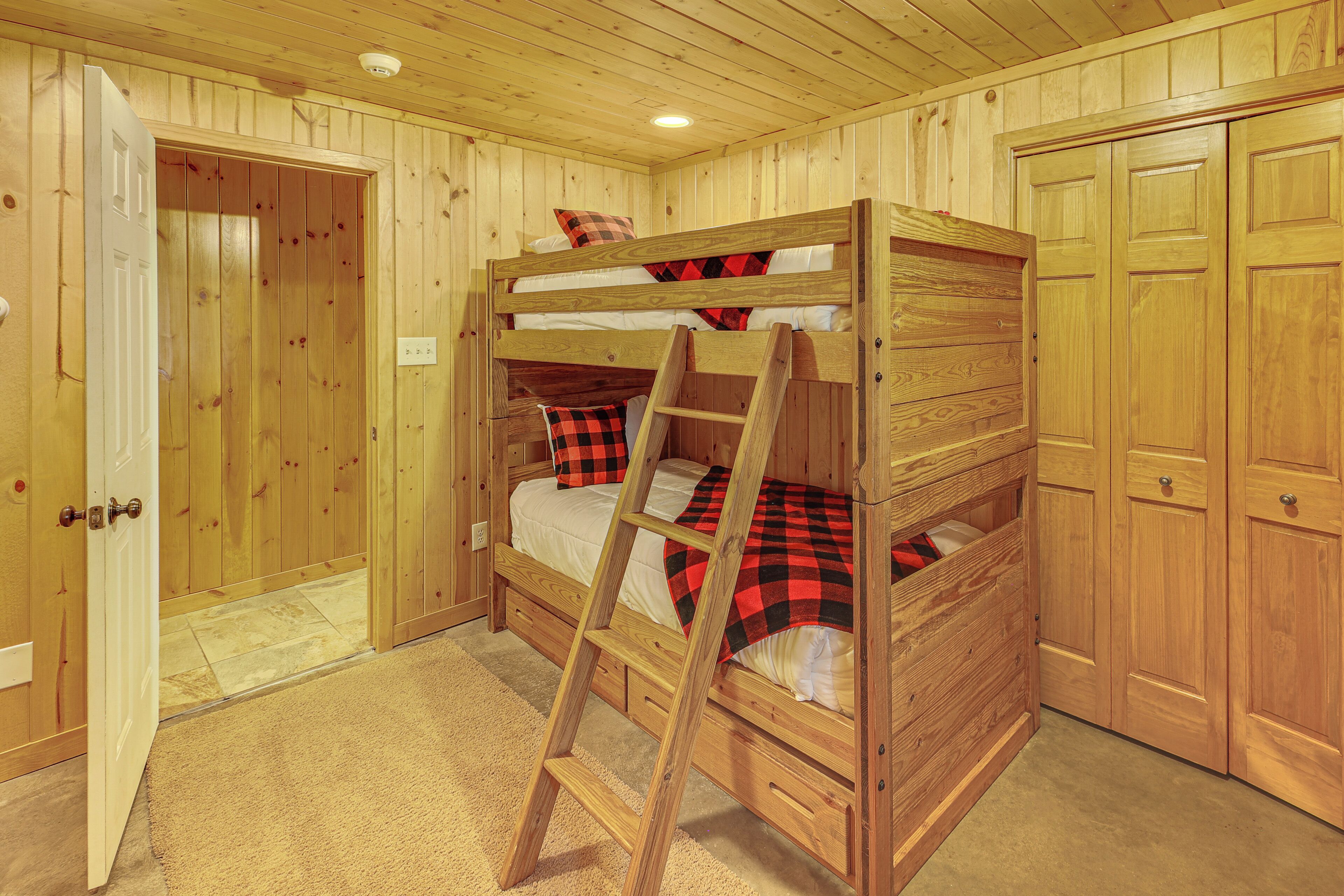 Ein Stockbett mit einer Leiter, Holzwänden, einer Tür und einem Schrank.