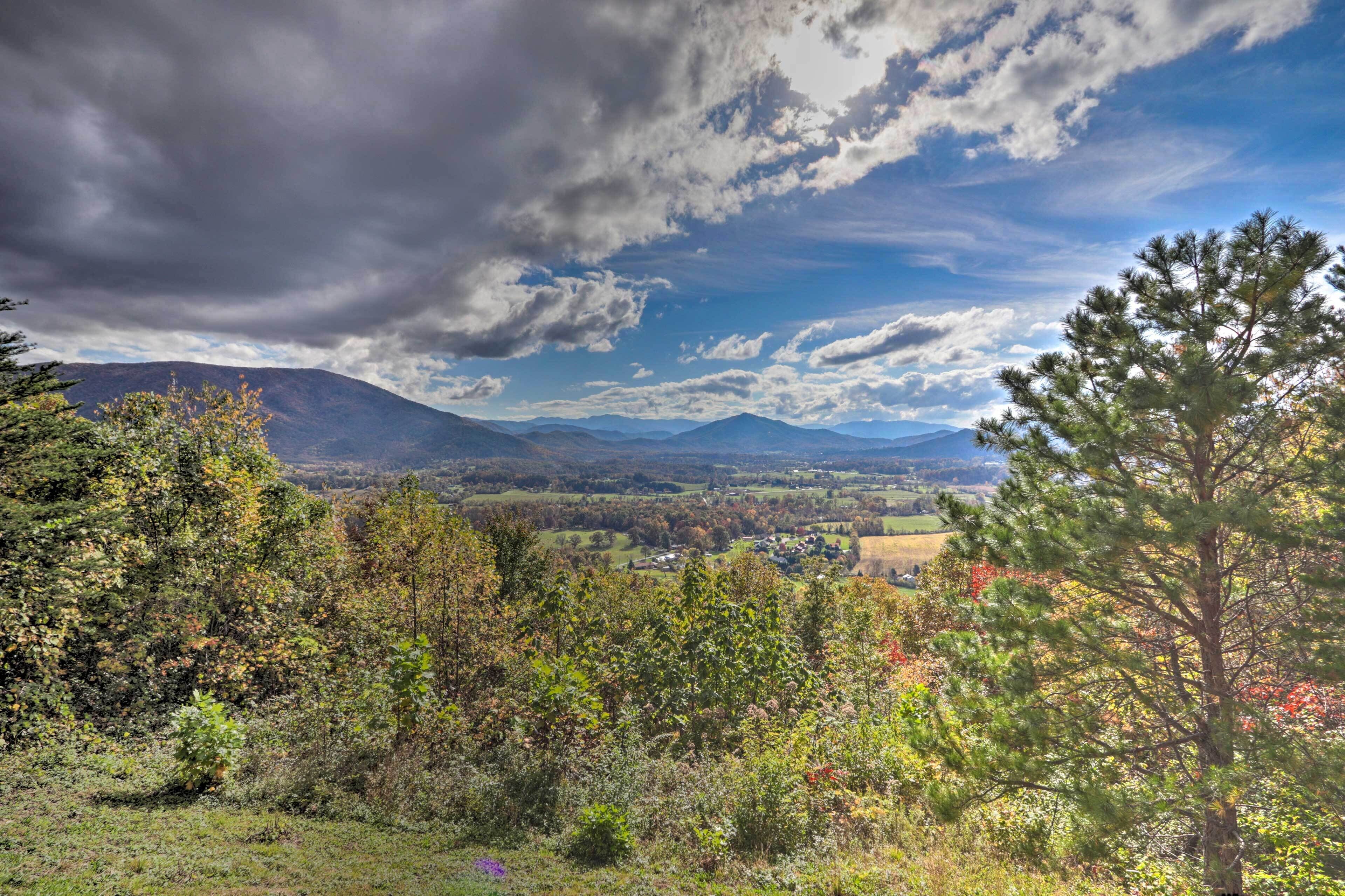 A mountainous landscape with a clear sky and scattered clouds.
