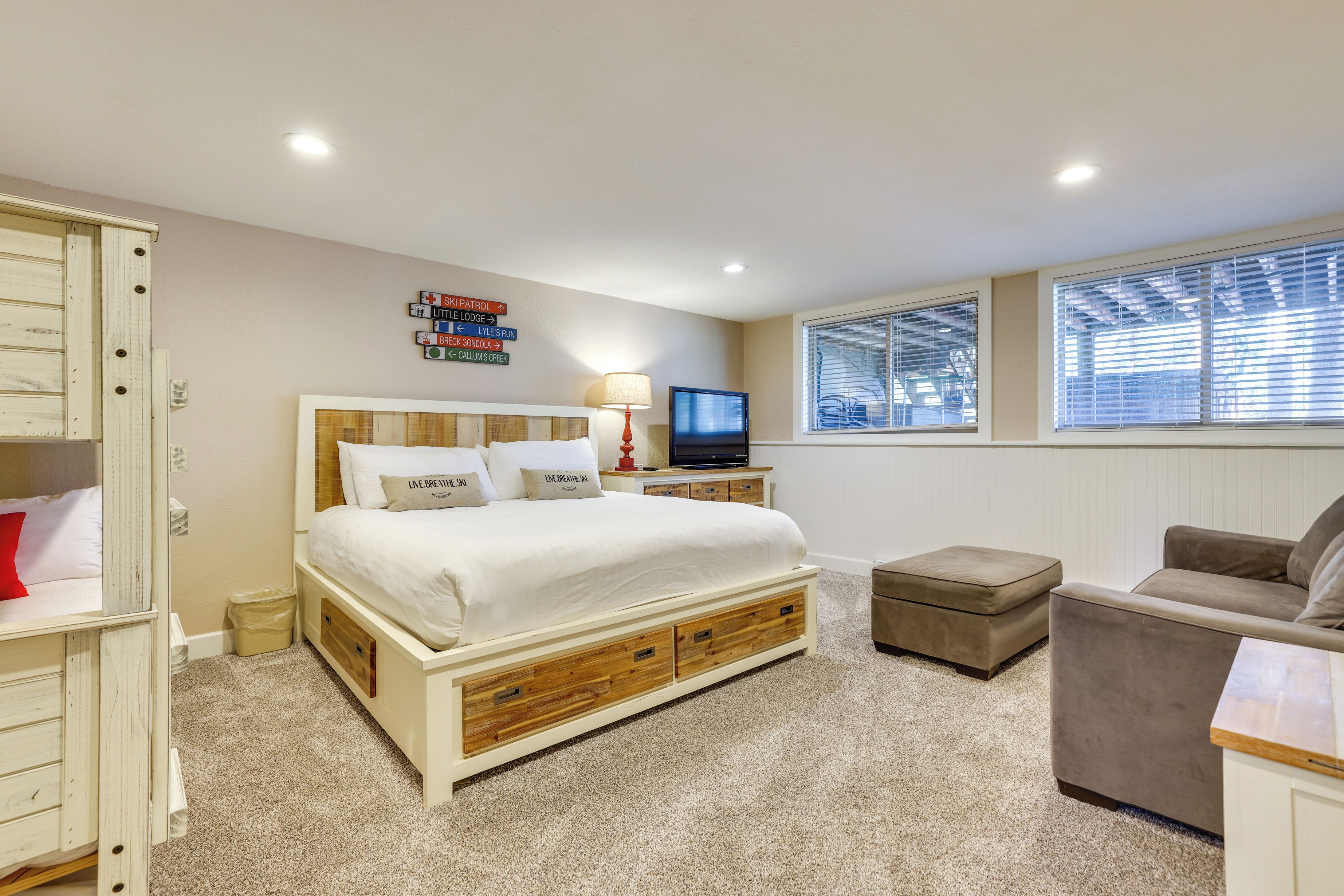 A bedroom with a bed, a TV, a desk, and a chair.