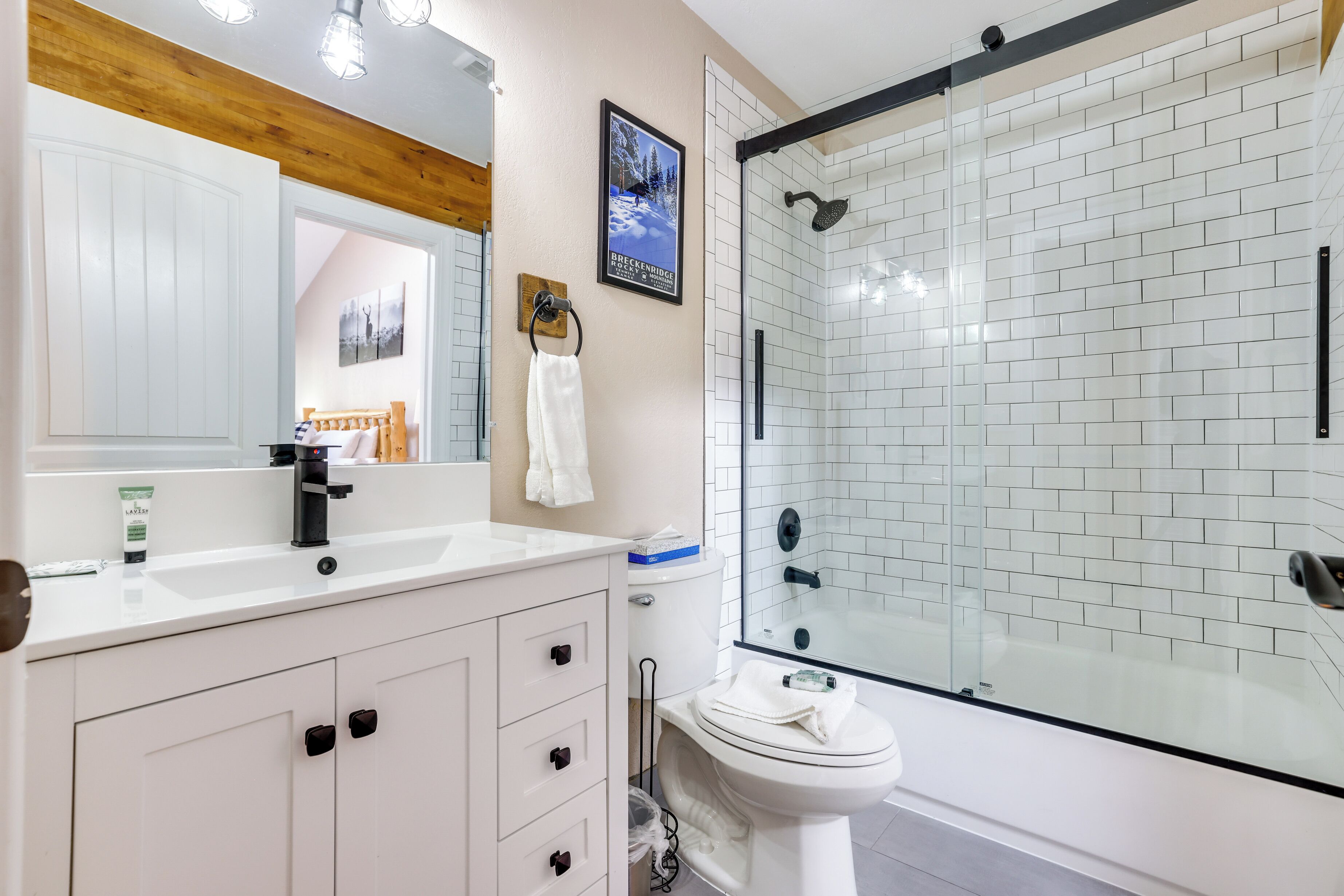 Une salle de bain moderne avec un lavabo blanc, des toilettes et une douche à parois de verre.