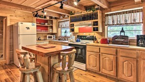 A wooden cabin kitchen with a refrigerator, stove, microwave, and wooden stools. - A-frame Cabin w/ Hot Tub < 1 Mi to Ober Gatlinburg (Gatlinburg)