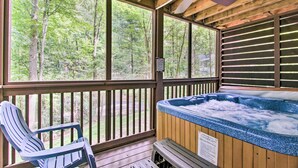 A wooden deck with a hot tub, a chair, and a view of a forest. - A-frame Cabin w/ Hot Tub < 1 Mi to Ober Gatlinburg (Gatlinburg)