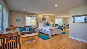A spacious bedroom with a large bed, a desk, and a sofa. - Ocean-view Lincoln City Retreat w/ 3 Viewing Decks (Lincoln City)