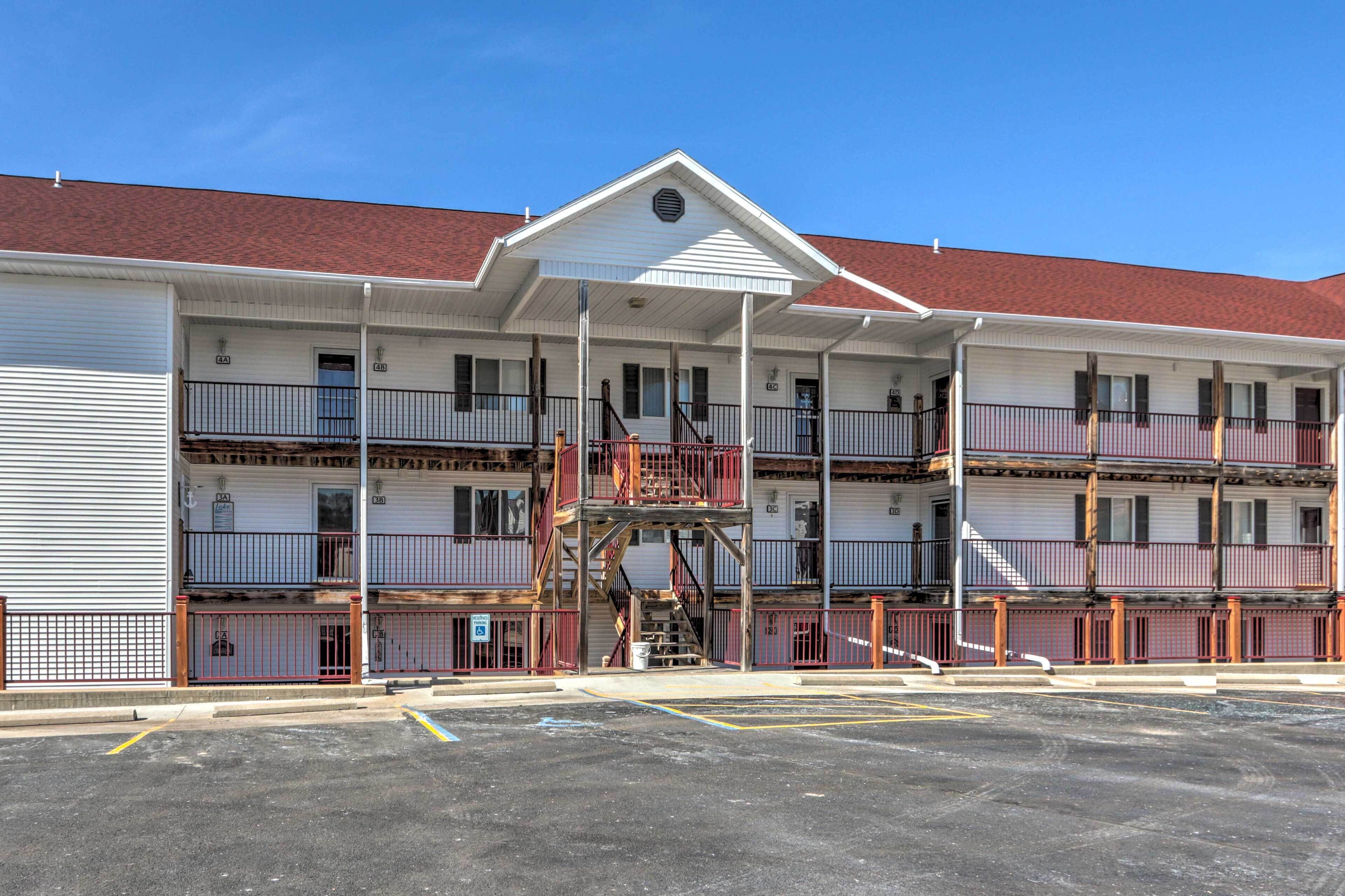 A multi-story motel with a central staircase, balconies, and a parking lot.