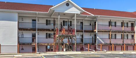 A multi-story motel with a central staircase, balconies, and a parking lot.