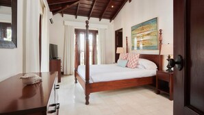 A bedroom with a four-poster bed, a television on a wooden dresser, and a painting on the wall. - 2min to Beach Rooftop Terrace 360 Views Pool BBQ - Casa Cazenovia 3BR (Tempate)