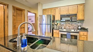 A modern kitchen with wooden cabinets, stainless steel appliances, and a granite countertop. - Cozy Branson Getaway ~ 2 Mi to Silver Dollar City! (Branson West)
