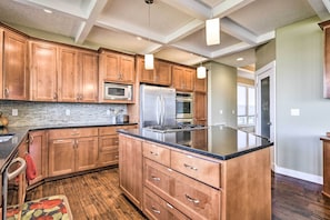 Une cuisine moderne avec des meubles en bois, des appareils en acier inoxydable et un grand îlot central.