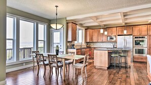 A spacious kitchen with wooden cabinets, a large island, and a dining area with chairs.