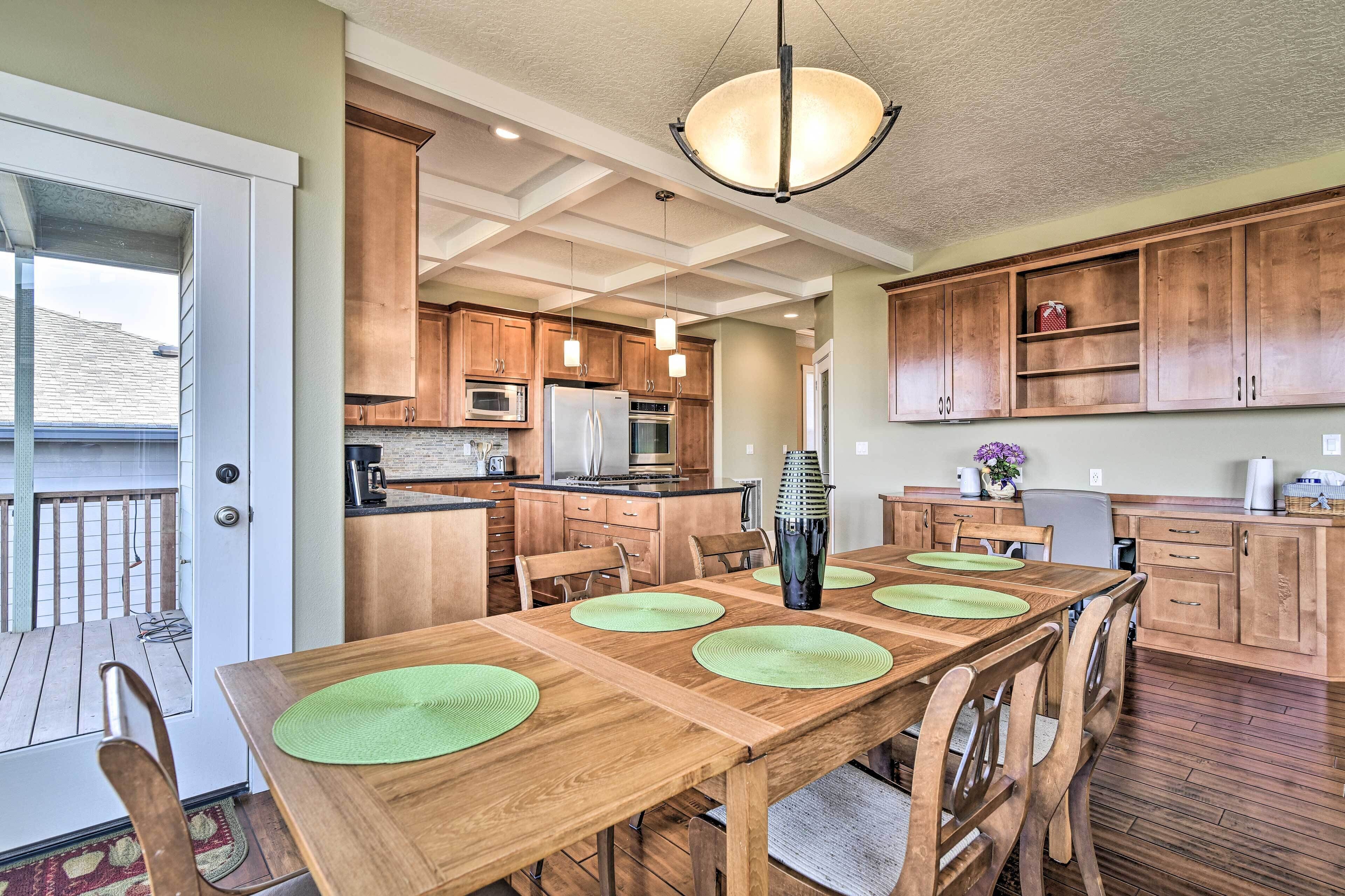 Una cocina amplia con armarios de madera, una isla central y una zona de comedor con individuales verdes.