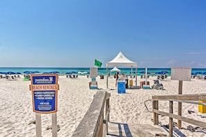 A beach rental sign listing available equipment like kayaks, surfboards, and bicycles.