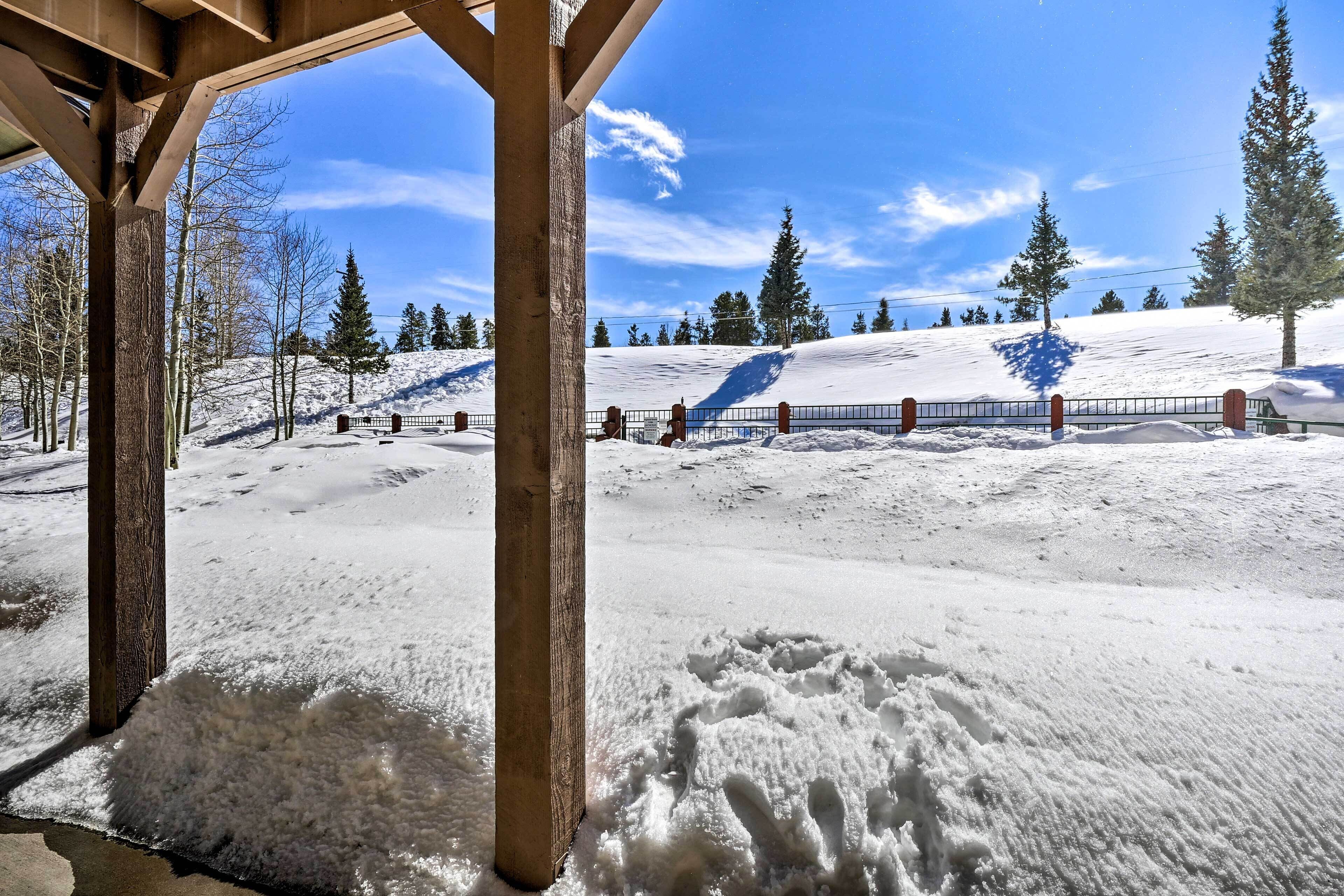 Una estructura de madera con suelo cubierto de nieve y cielo despejado.
