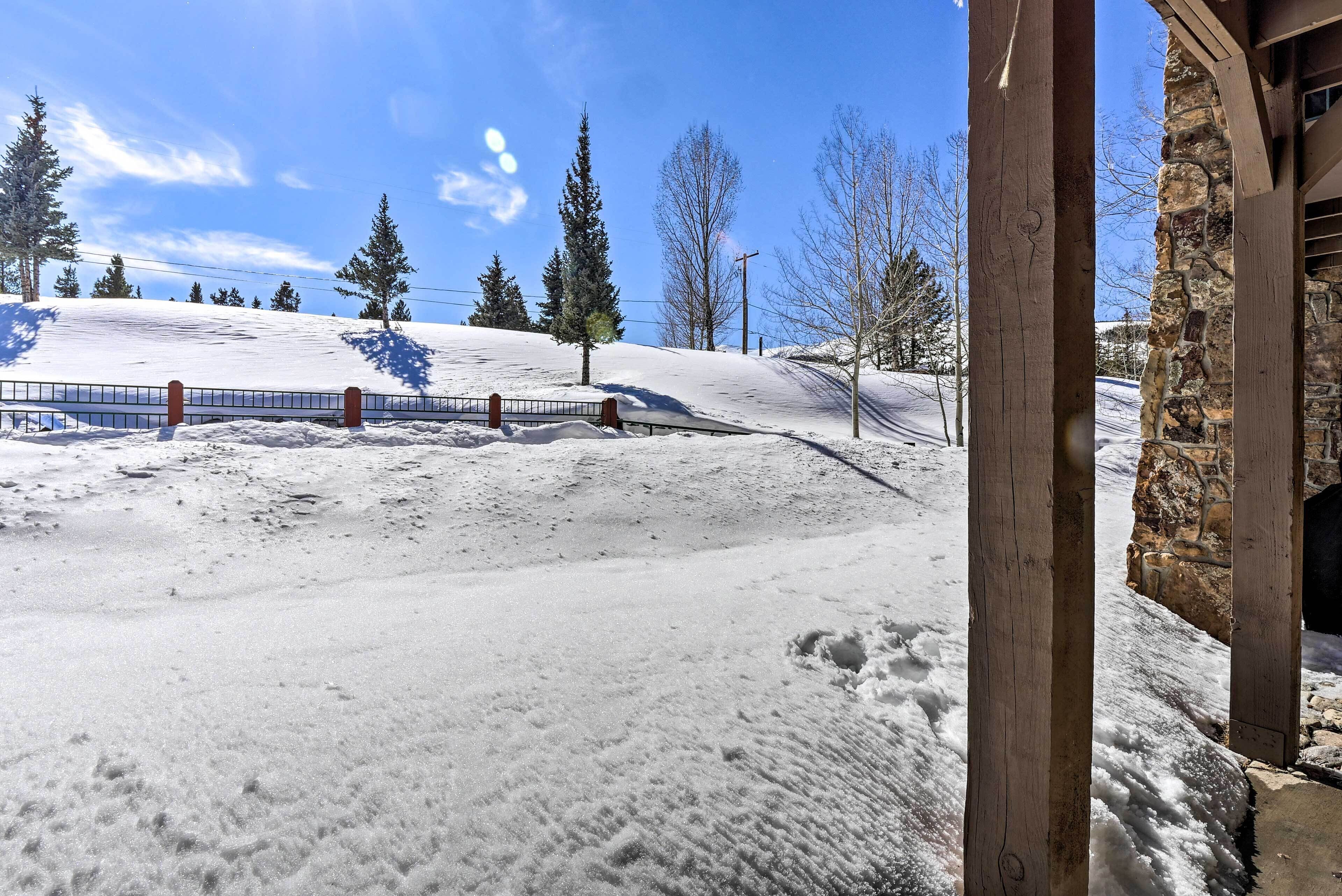 Ett snötäckt landskap med ett trästaket och träd.