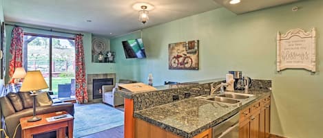 A modern kitchen with granite countertops, wooden cabinets, and a built-in dishwasher.