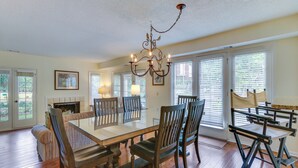 A dining area with a glass-top table, wooden chairs, and a chandelier. - 1 Mi to Beach: Family-friendly Evian Resort Condo! (Hilton Head Island)