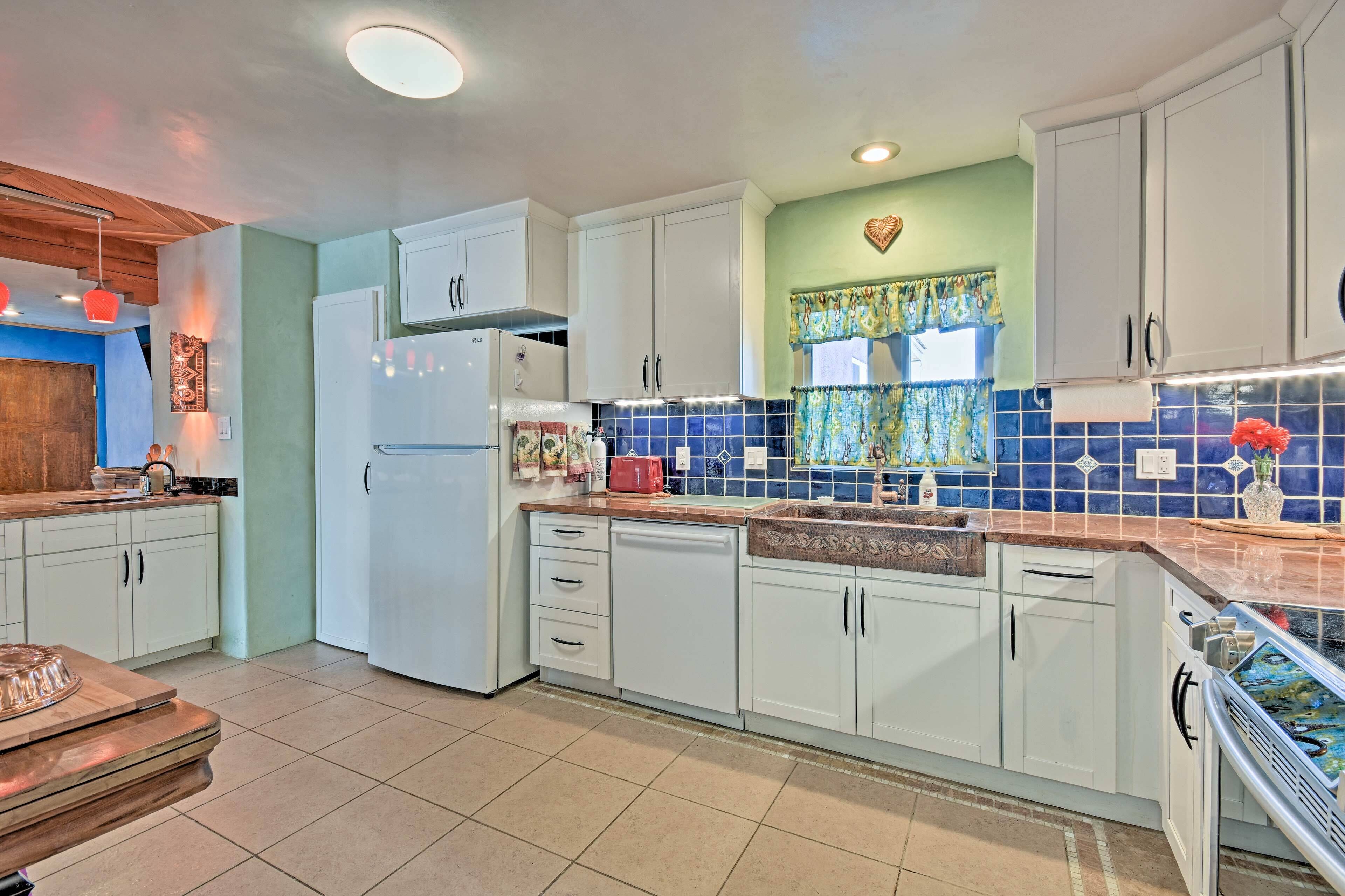 Una cocina moderna con armarios blancos, horno empotrado y salpicadero de azulejos.