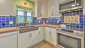 A kitchen with white cabinets, a stainless steel microwave, and an oven. - Cozy 'blue Adobe' w/ Steam Room 2 Mi. From Taos! (El Prado)