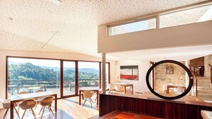 A modern interior with a large dining area, a circular mirror, and a view of the outdoors. - Casa Fumanal - Unique Property for up to 24 (Abizanda)