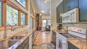 A modern kitchen with granite countertops, stainless steel appliances, and large windows offering views of the outdoors. - Creekside Mtn House w/ Deck: 8 Mi to Idaho Springs (Dumont)