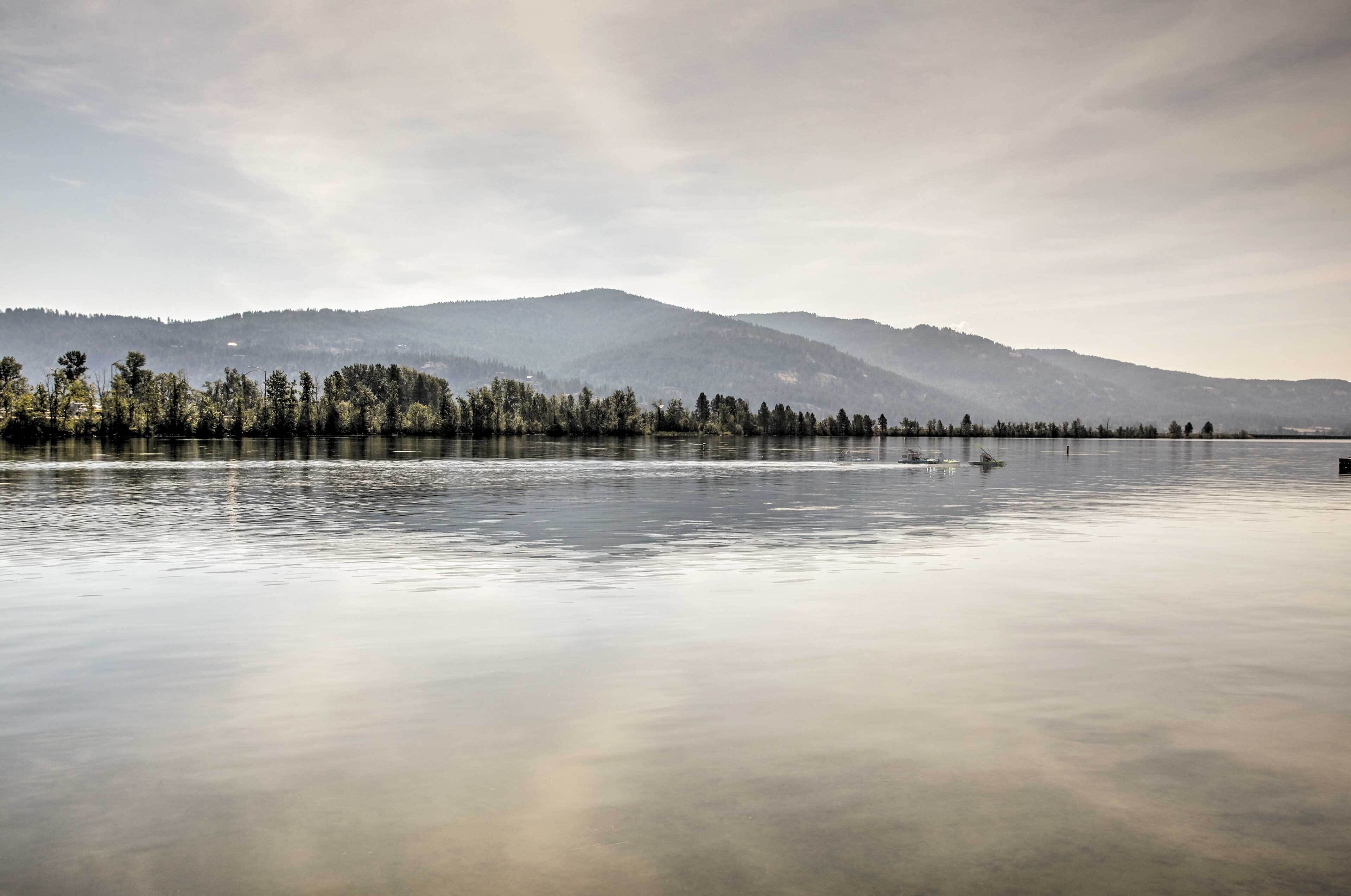 Un lac paisible, avec une chaîne de montagnes boisées en arrière-plan.
