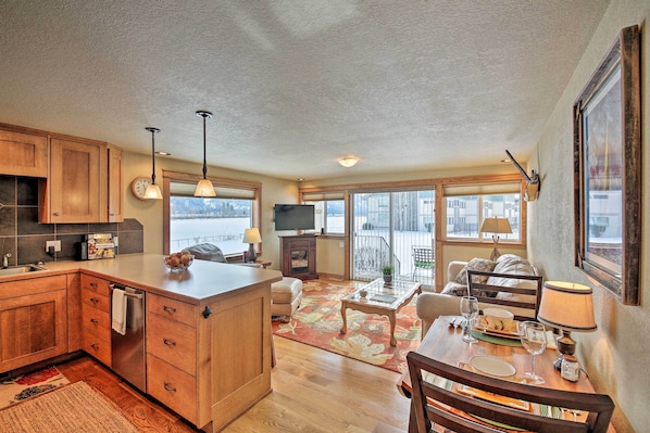 A spacious kitchen with wooden cabinets, a large island, and a dining area with a table and chairs.
