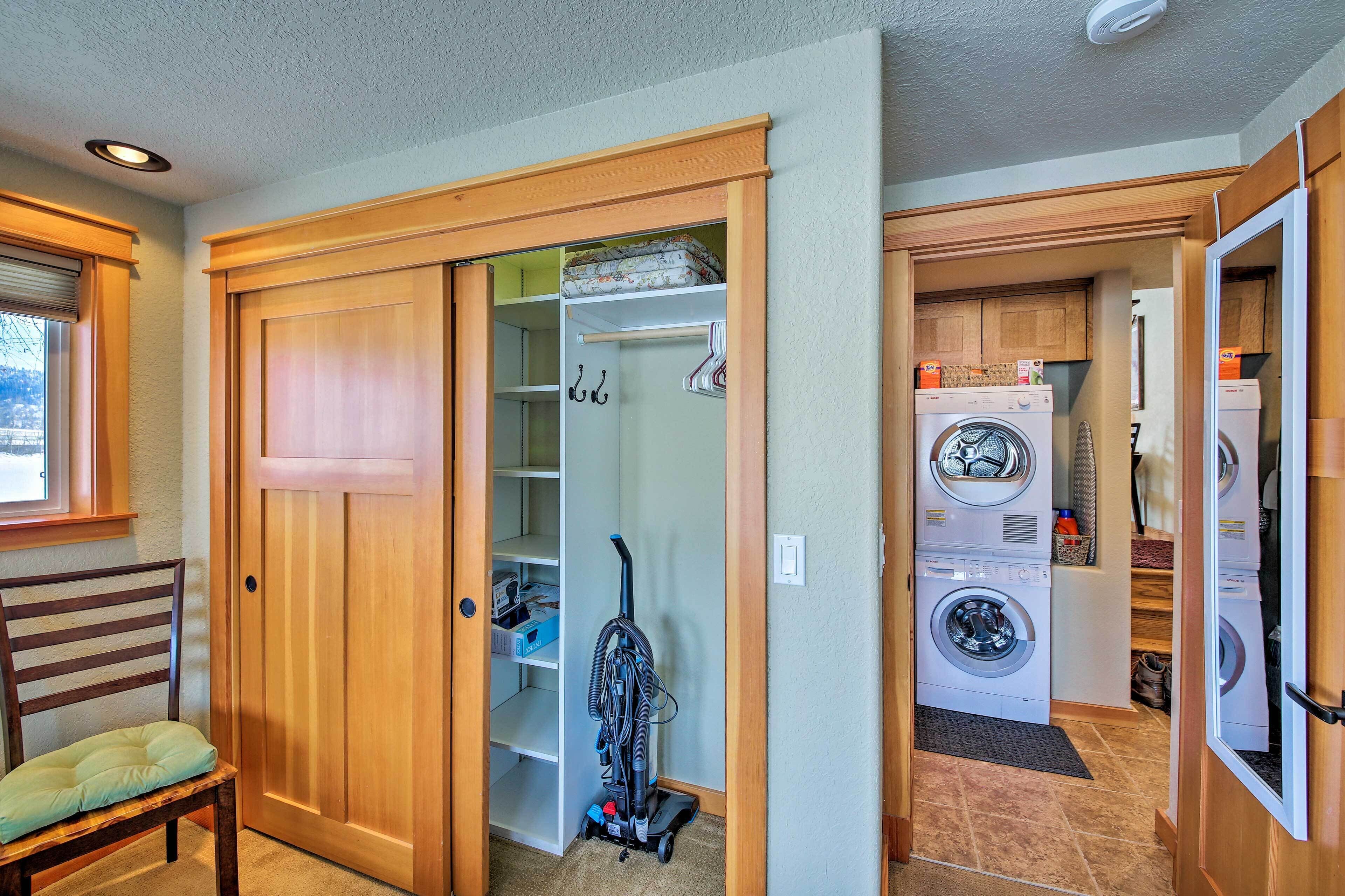 A laundry room with a washing machine, dryer, and a vacuum cleaner.