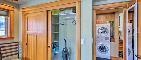 A laundry room with a washing machine, dryer, and a vacuum cleaner.
